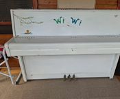 Upright piano painted white with drawings
 - Image